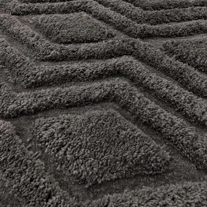 Dark grey textured rug with raised geometric pattern and soft pile