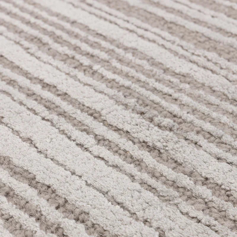 Close-up of textured cream and beige wool rug with subtle striped pattern