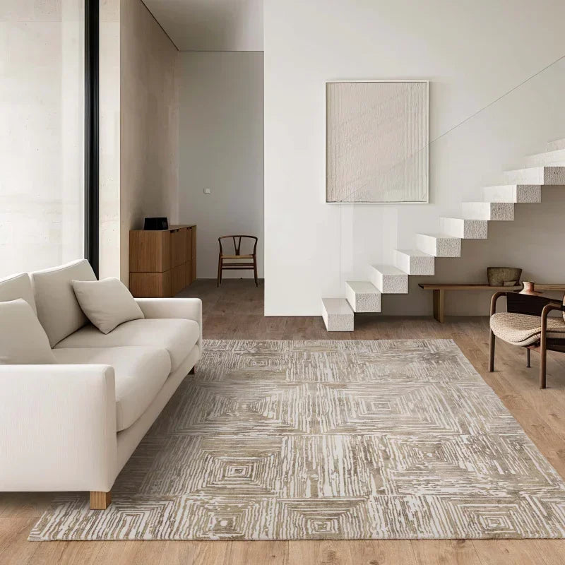 Modern beige sofa with neutral patterned area rug in minimalist living room