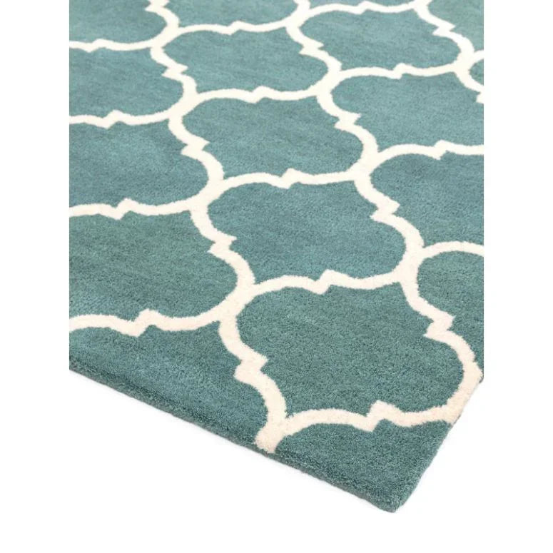 Blue geometric patterned rug with white trellis design, close-up of corner view