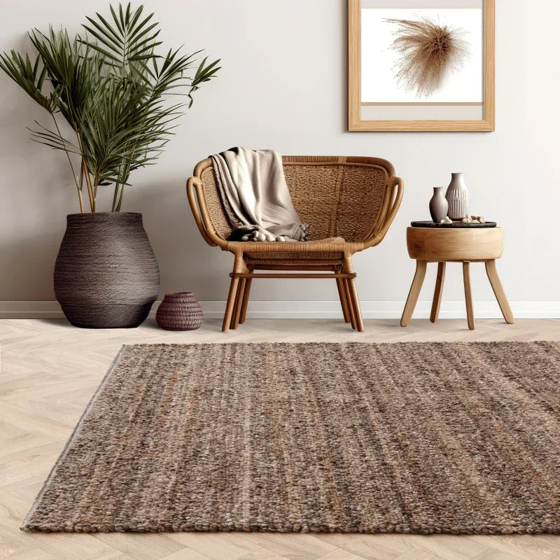 Brown textured area rug in modern living room with rattan chair and neutral decor