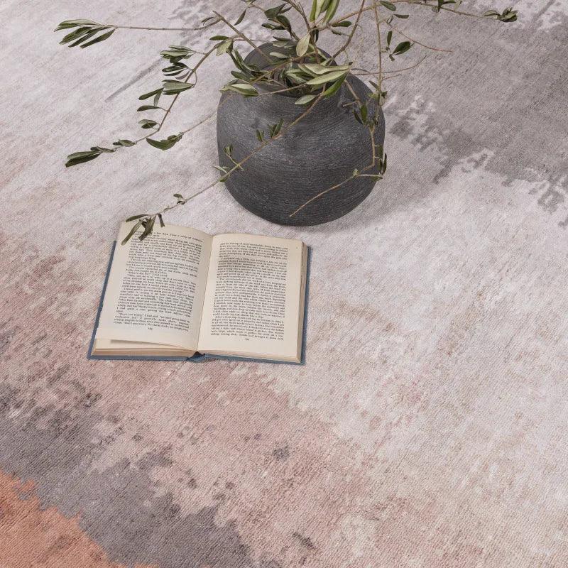Modern ombre area rug with open book and ceramic vase with green foliage