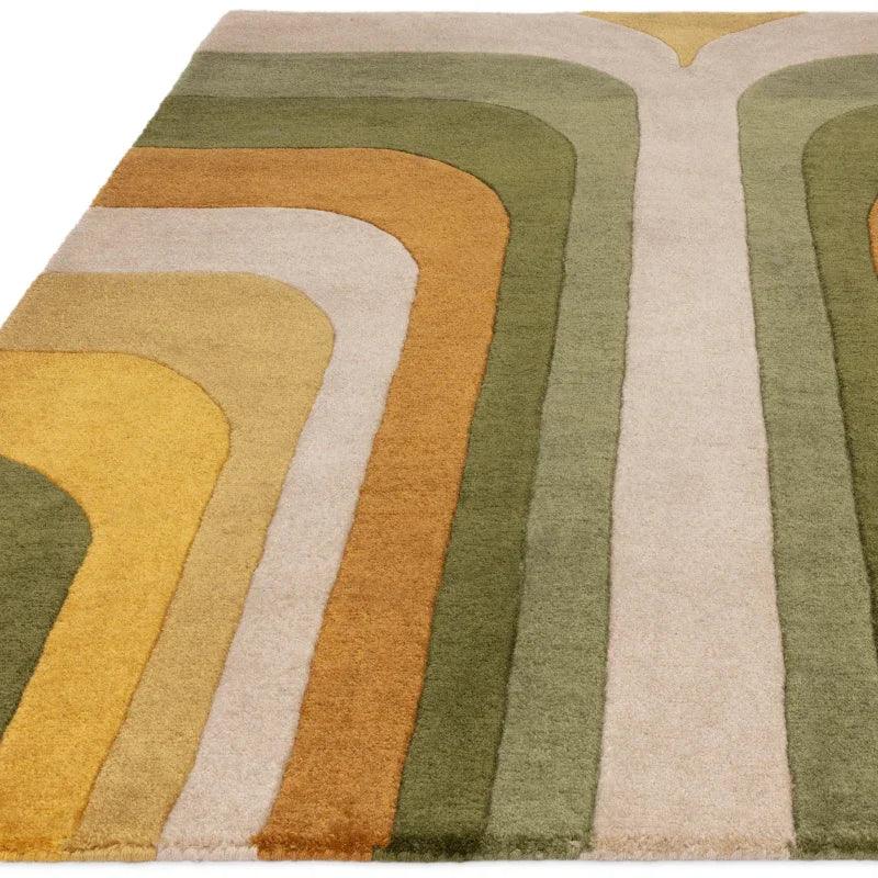 Geometric area rug with curved stripes in green, gold and beige tones, angled view
