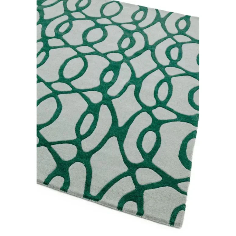 Modern area rug with green abstract pattern on a light grey background, angled corner view