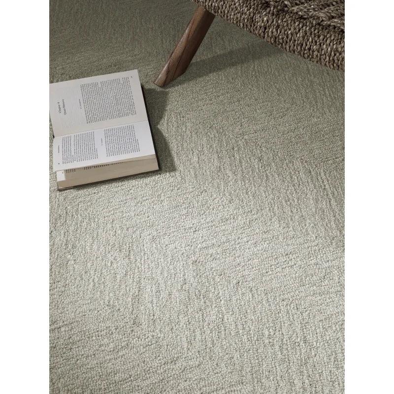Textured beige carpet with open book and woven chair leg in living room setting