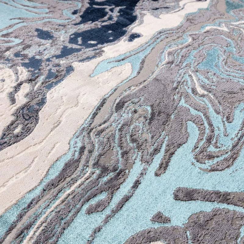 Abstract pattern area rug in grey, blue and cream with textured high-low pile detail