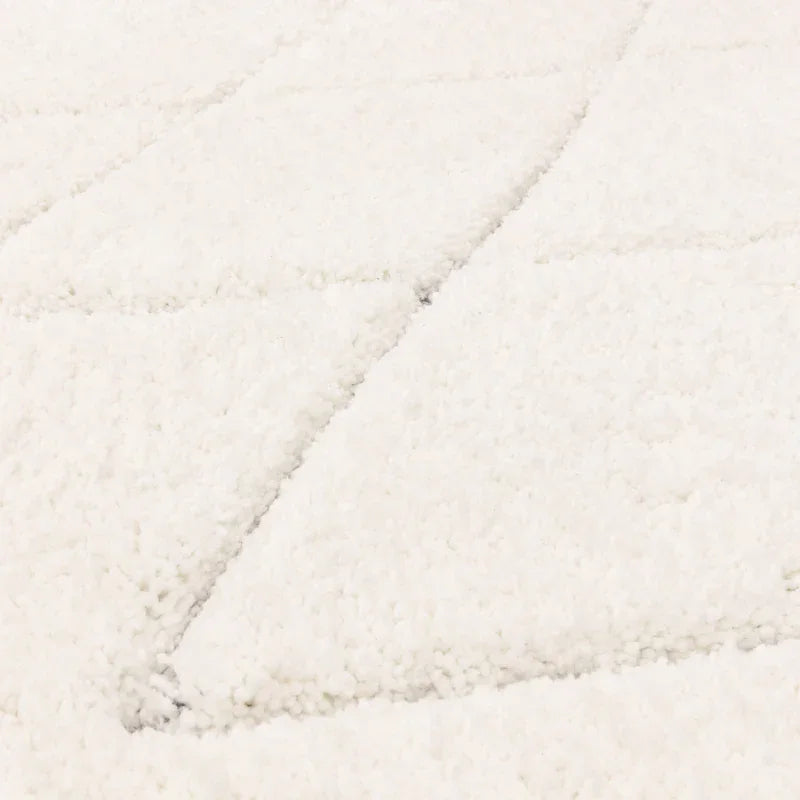 Close-up of white plush rug with subtle geometric pattern texture