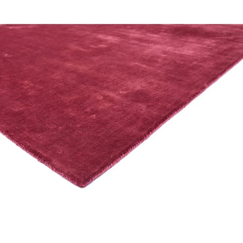 Close view of red velvet rug with soft texture and finished edge