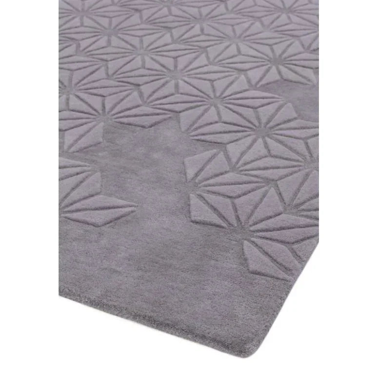 Grey rug with geometric embossed pattern and soft textured surface, corner angle view