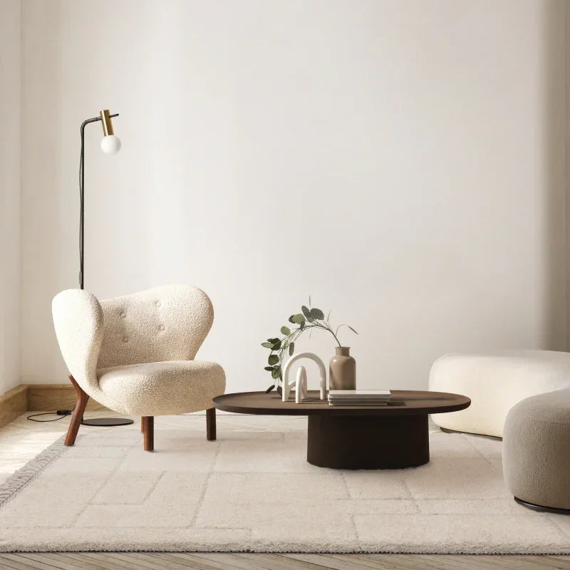 Cream boucle accent chair and low dark wood coffee table in modern living room