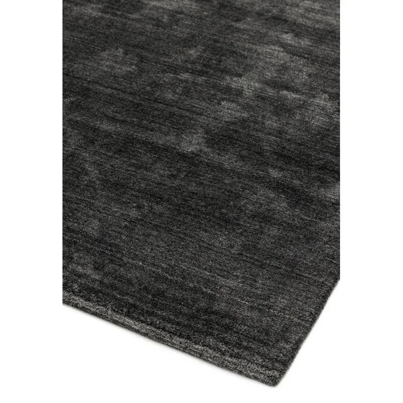 Dark charcoal rug corner with subtle textured finish