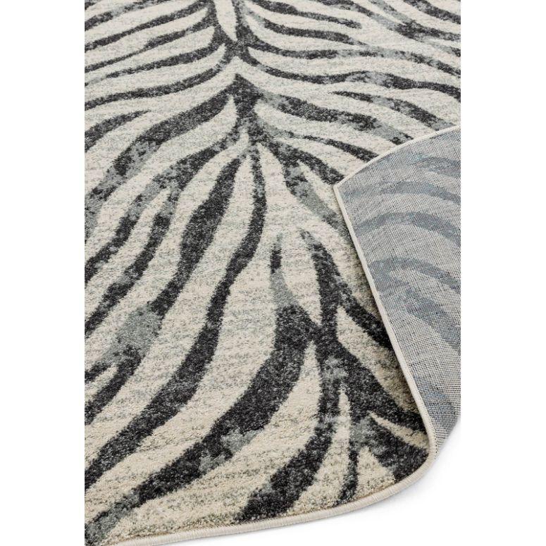 Grey and white zebra pattern area rug with corner folded to show backing