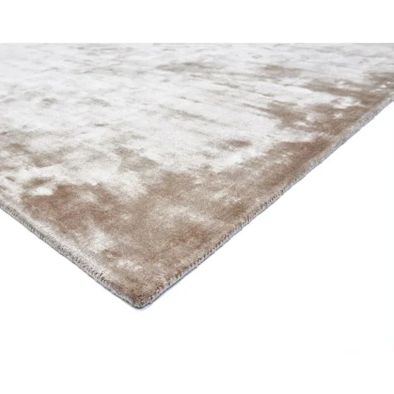 Close up of beige and cream area rug with soft, plush texture and finished edge