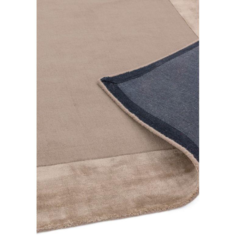 Beige area rug with visible corner showing non-slip backing and soft texture