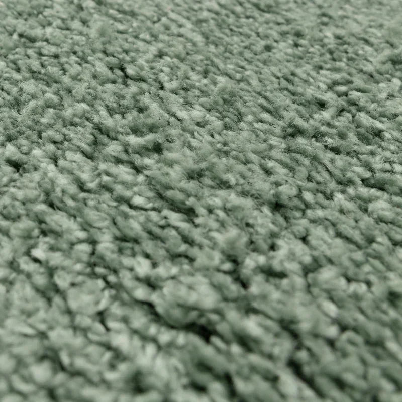 Close-up of textured green carpet fabric with dense pile