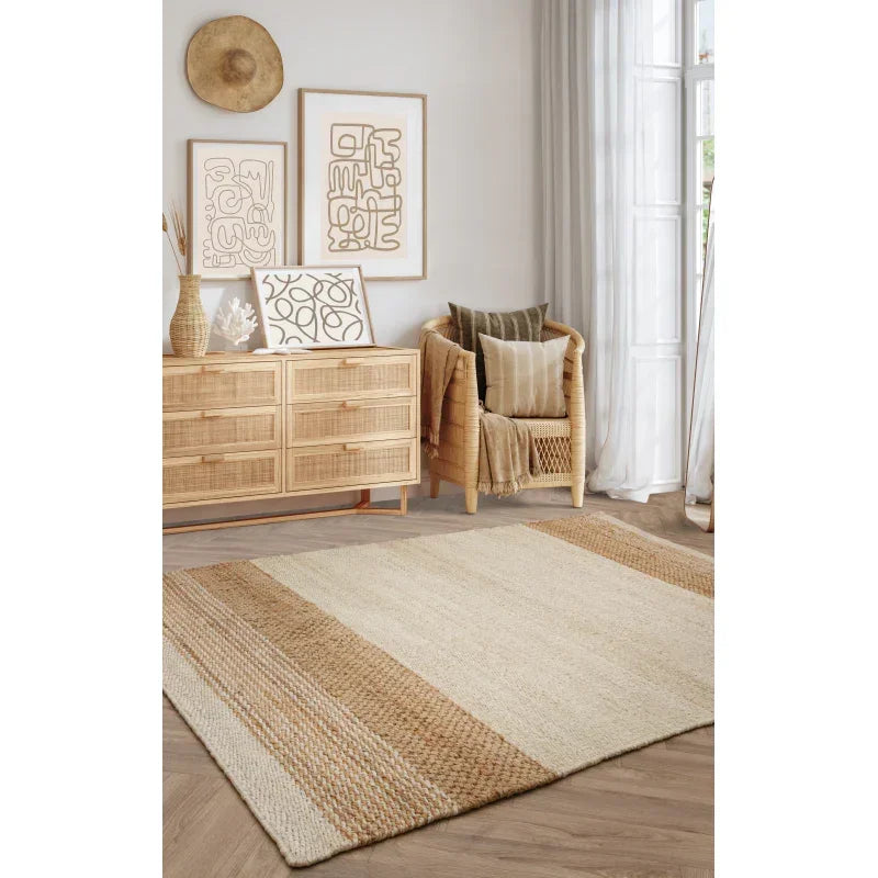 Beige and natural jute area rug in a modern living room with rattan furniture and wall art