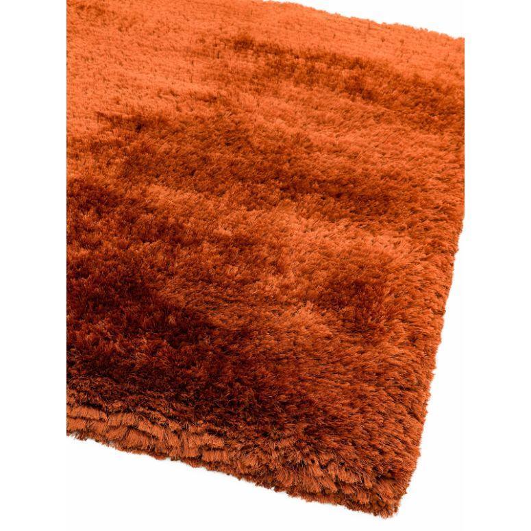 Close up of orange shaggy area rug with soft, thick pile texture