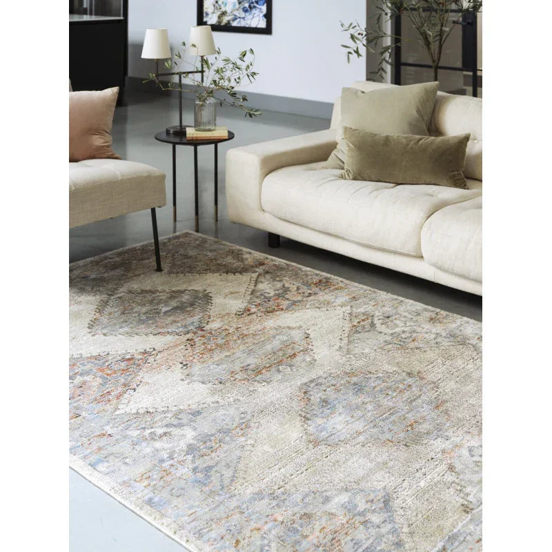 Beige patterned rug in modern living room with cream sofa and accent cushions