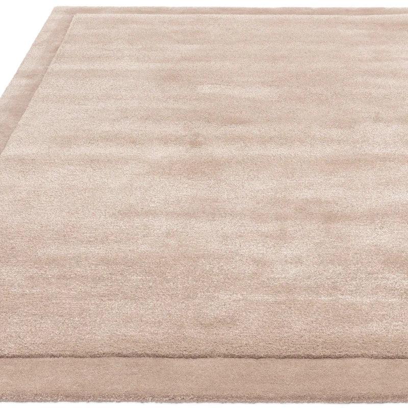 Large beige rectangular rug with subtle border and soft pile texture