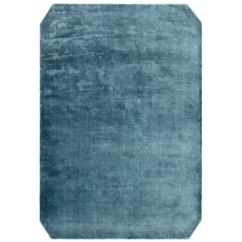 Blue velvet area rug with clipped corners and soft texture