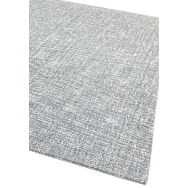 Light blue textured rug with subtle crosshatch pattern, corner view on white background