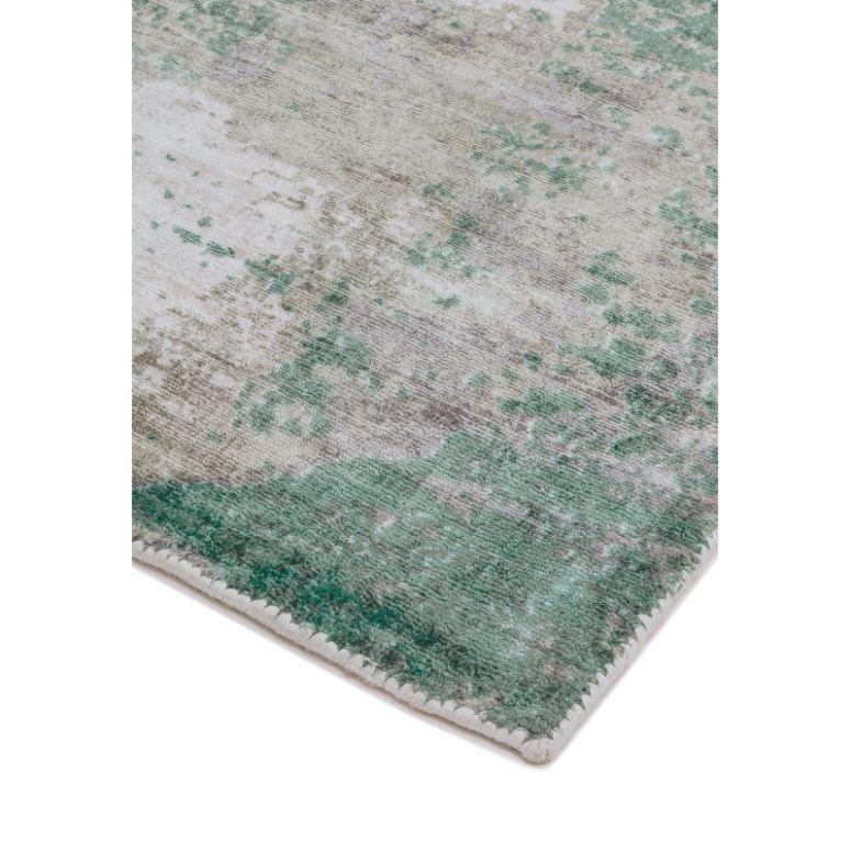 corner of abstract green and beige area rug with textured pattern
