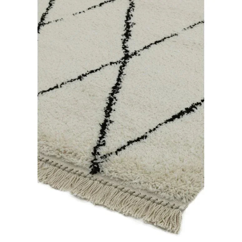 cream rug with black geometric lines and fringe detail on edge