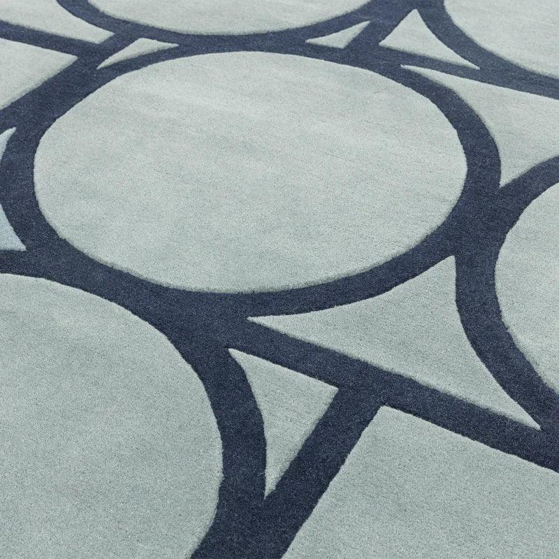 Light blue area rug with dark blue geometric circle pattern close-up