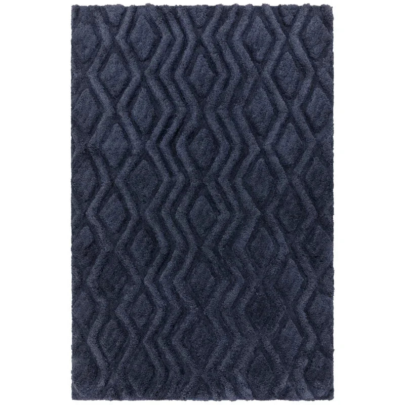 Navy blue textured rug with raised geometric diamond pattern, top-down view
