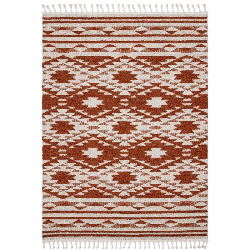 Terracotta and cream geometric patterned rug with fringed edges