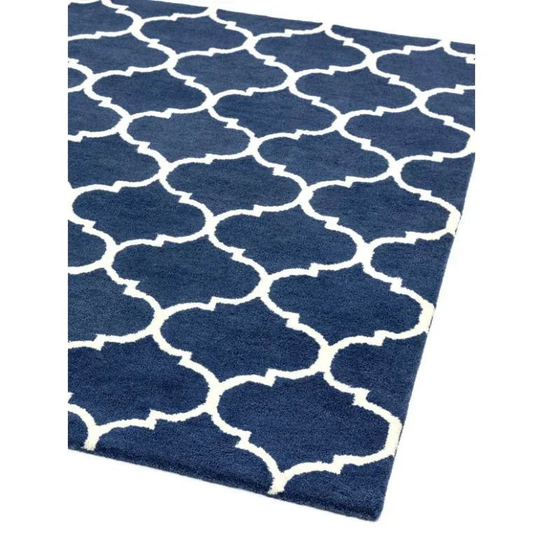 Navy blue area rug with white geometric trellis pattern, close corner view