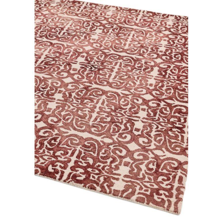 Red and cream patterned area rug with abstract geometric design, corner view