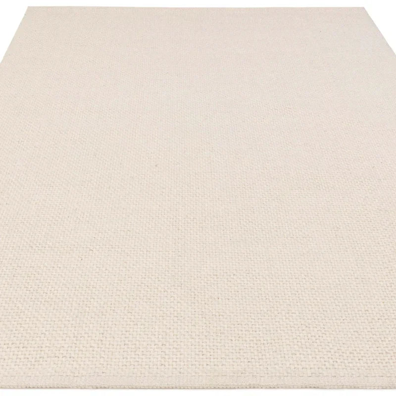 Cream woven area rug with textured flat weave, shown from corner angle