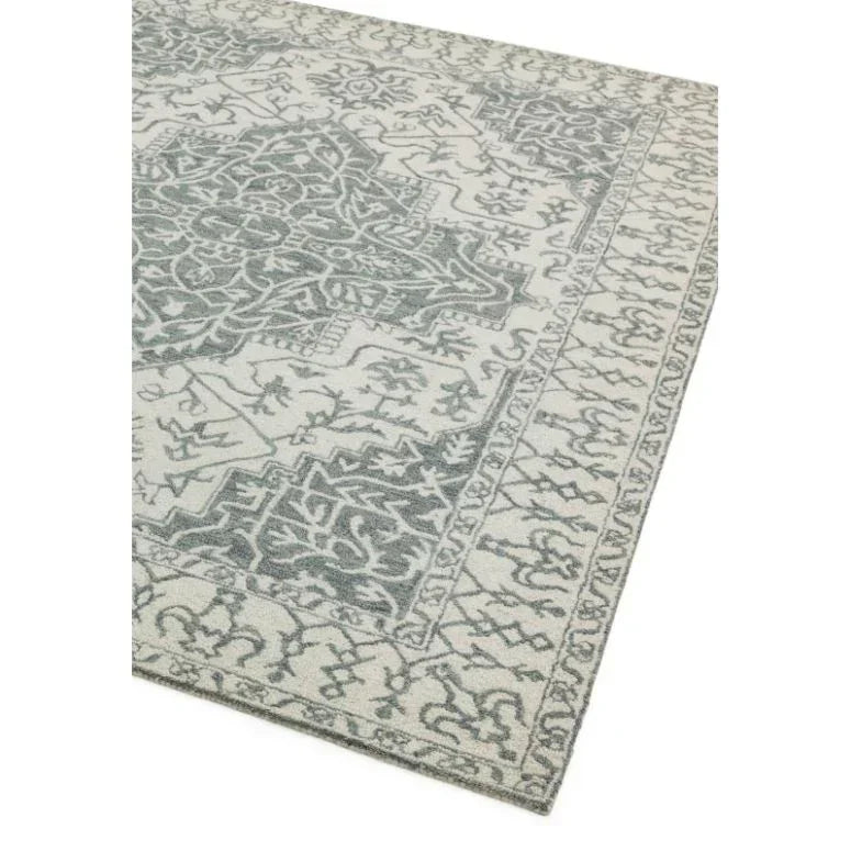Grey patterned area rug with intricate border and central floral design on cream background