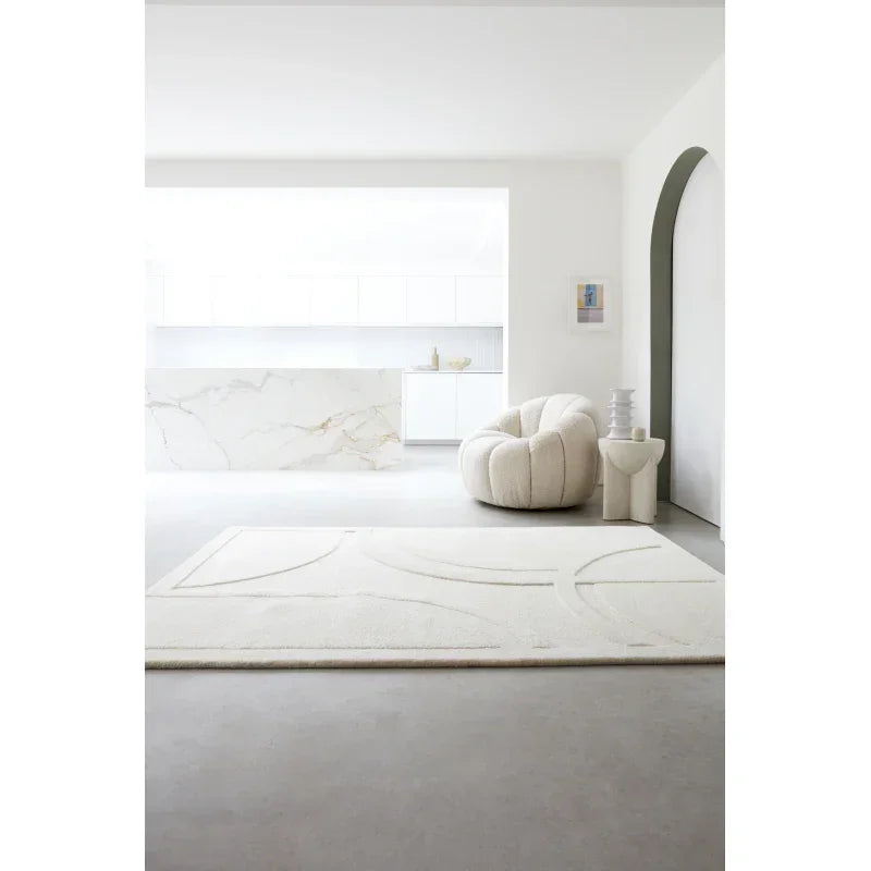 Modern cream rug on concrete floor with white armchair in minimalist living room