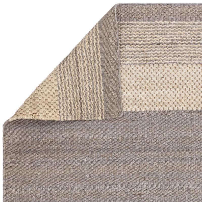 Beige and grey woven rug corner detail with textured pattern