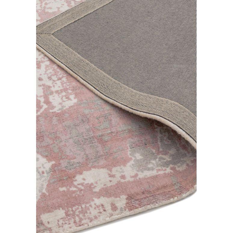Close-up of pink and grey patterned rug with visible corner showing non-slip backing