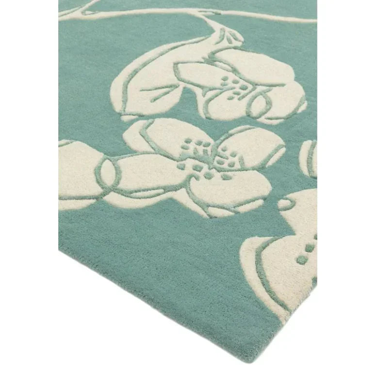 Teal floral rug with cream embossed flower pattern, corner view showing texture detail