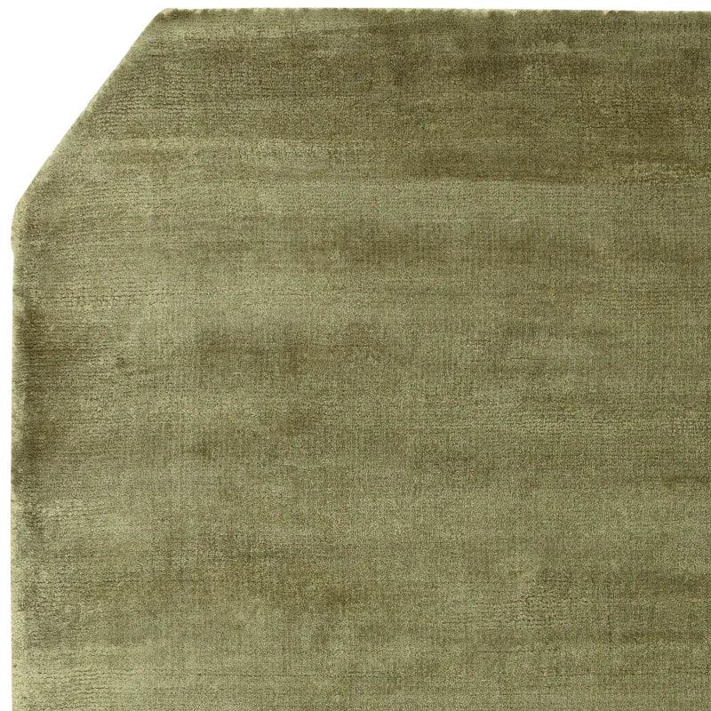 Olive green area rug corner with angled edge and soft textured surface