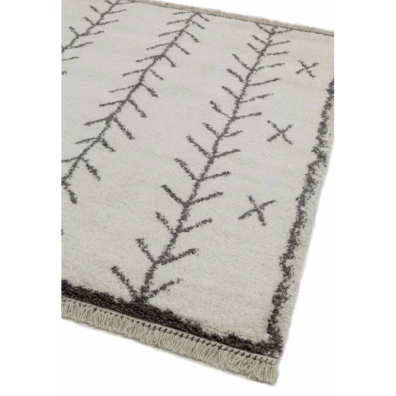 Cream area rug with black geometric pattern and fringe detail on edge