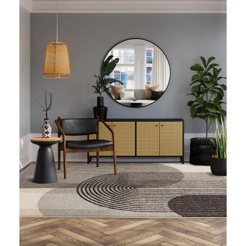 Modern living room with rattan sideboard, round wall mirror, black armchair and indoor plants