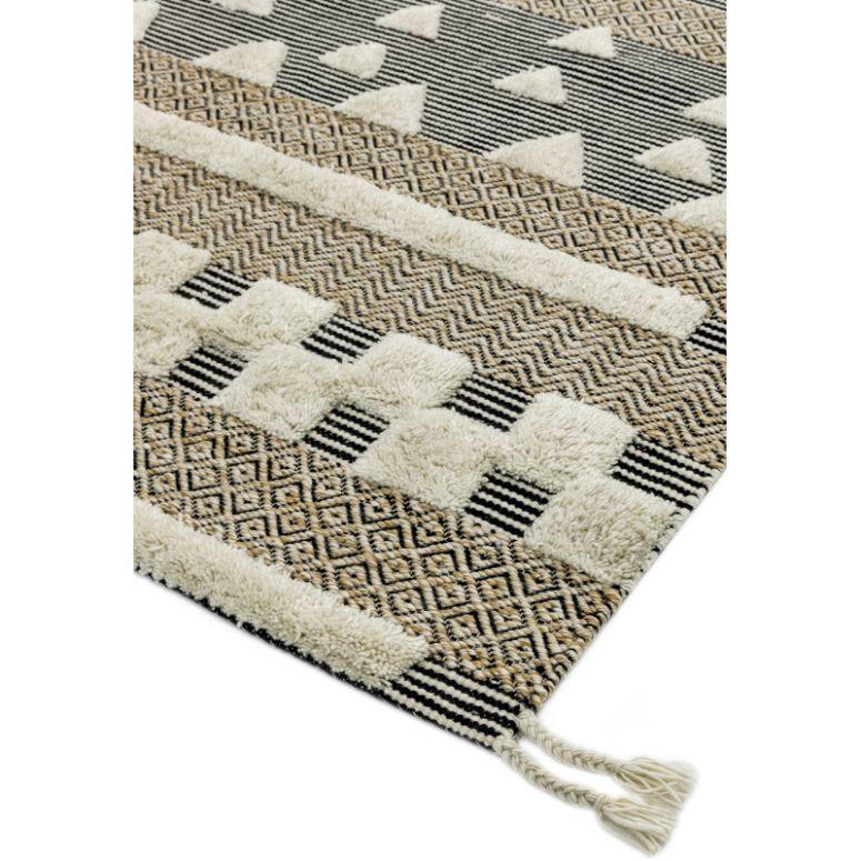 Geometric pattern area rug in neutral tones with textured pile and tasseled edge