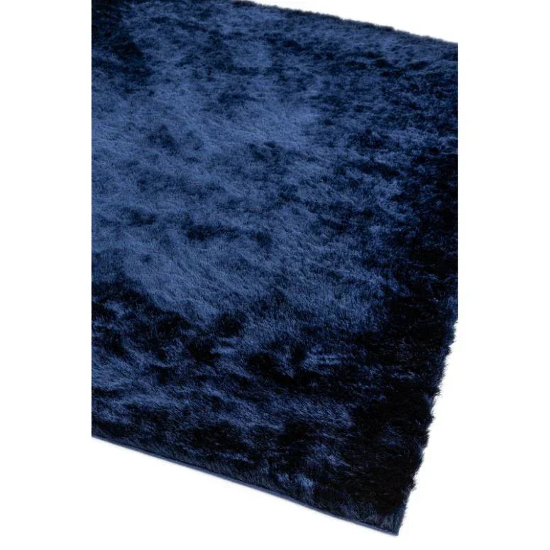 Dark blue shaggy rug with soft pile, close-up of corner detail