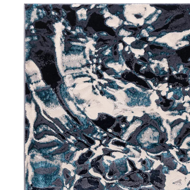 Contemporary area rug with abstract blue, black, and white floral pattern close-up