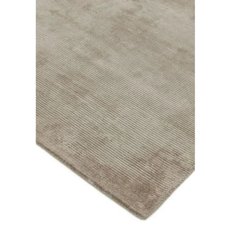 Beige striped area rug with soft textured surface, close-up of corner detail