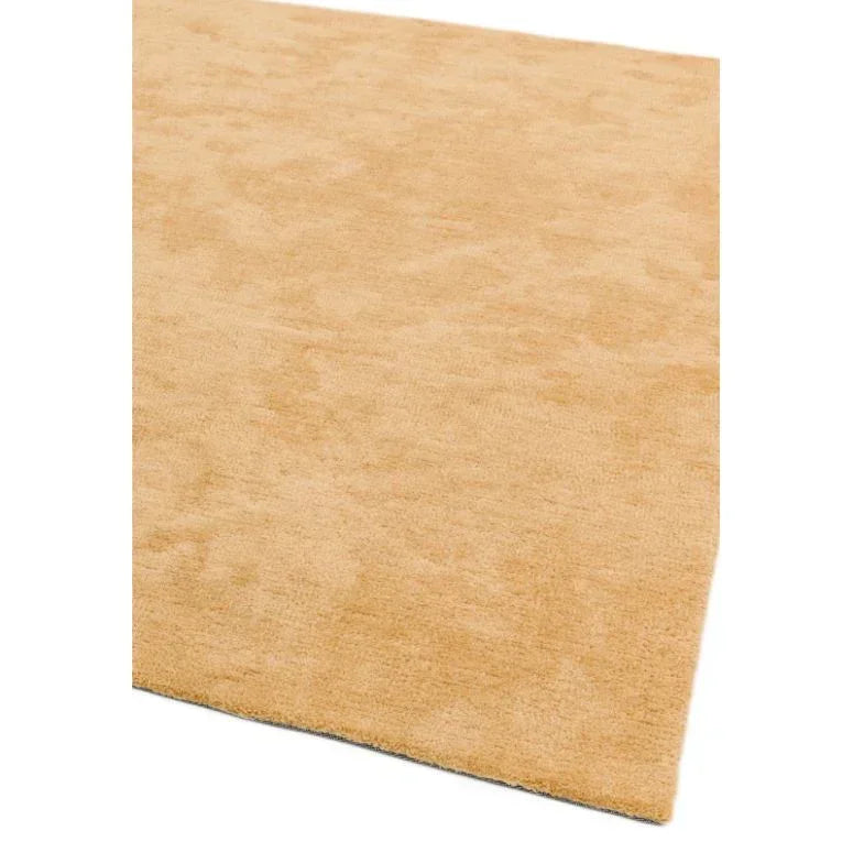 Beige wool rug with soft texture and neatly finished edge, shown from an angled view