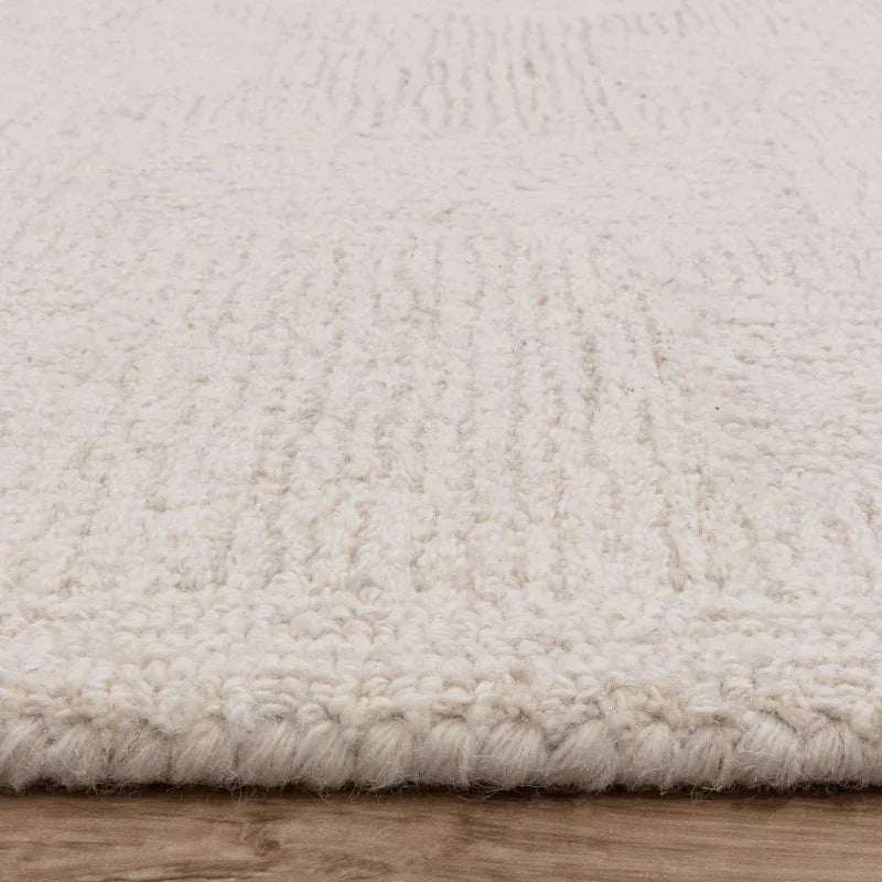 Cream textured wool rug on wooden floor close-up