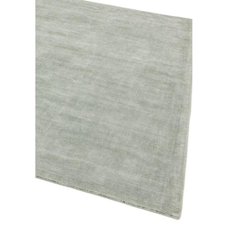 Light grey area rug with subtle textured finish, corner angle view