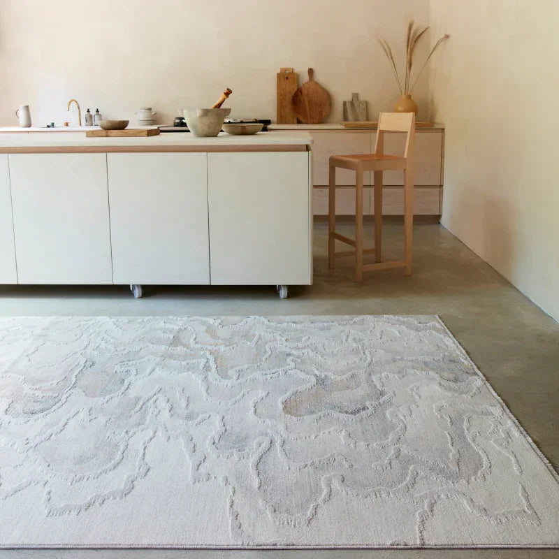 Textured cream area rug on concrete floor in modern kitchen with wooden bar stool