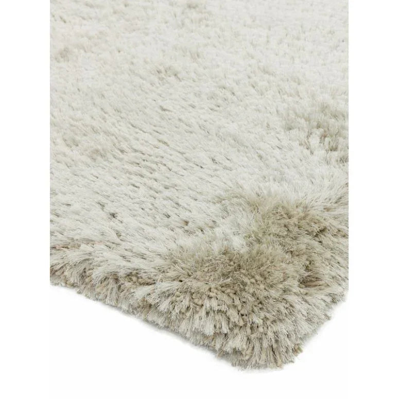 Close-up of cream shaggy rug corner with thick, soft pile texture